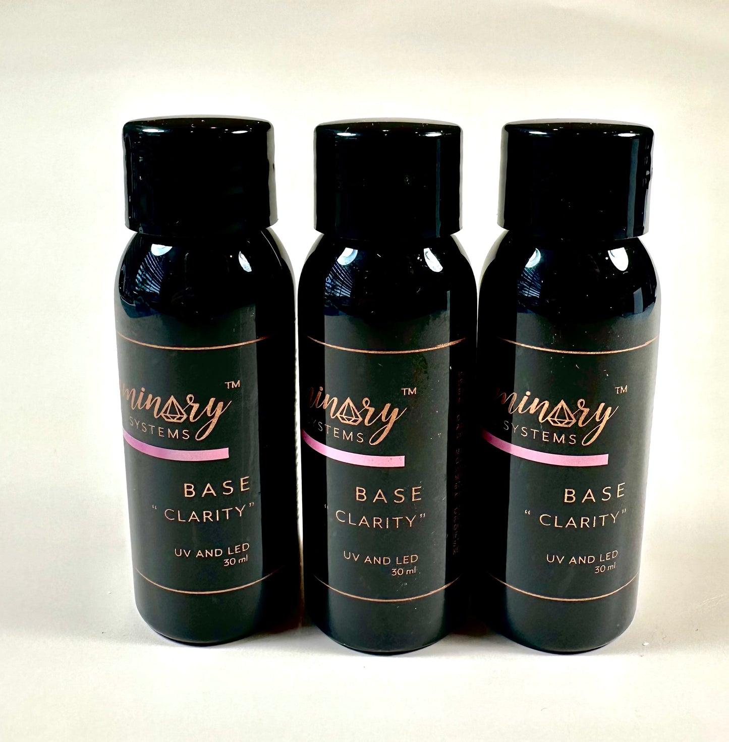 Three bottles of 'Ministry Systems Base Clarity' on a white background