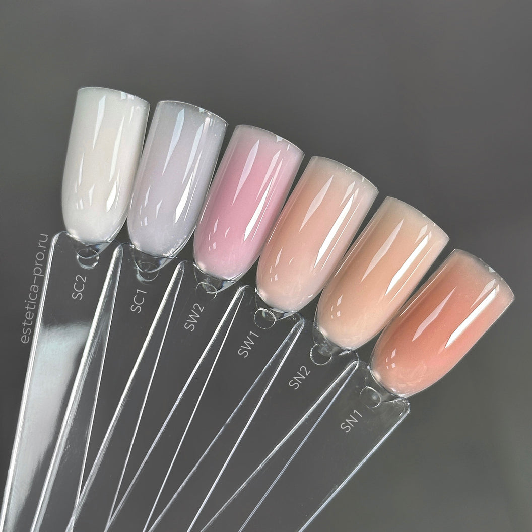 Set of nail samples with gradient colors on clear stands against a dark background